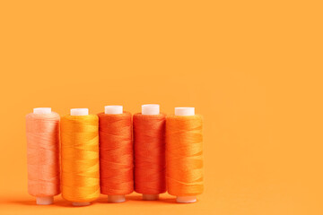 Spools of thread on orange background