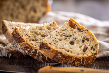 Photo of sliced ​​baked sourdough bread on wooden table.
