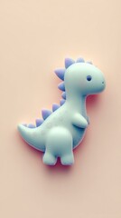 Cute blue dinosaur toy on a light pink background.