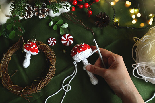Merry Christmas. Crochet red fly agaric mushroom for your Christmas tree decoration. DIY Christmas tree decorations. Celebrating with kids. A cozy home on Christmas Eve.