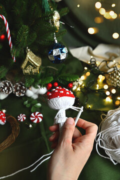 Merry Christmas. Crochet red fly agaric mushroom for your Christmas tree decoration. DIY Christmas tree decorations. Celebrating with kids. A cozy home on Christmas Eve.
