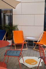 A Colorful Outdoor Lounge Area with Contemporary Modern Chairs and a Fun Egg Rug Design