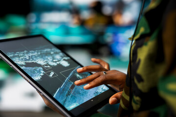 Close up of military defense security agent using device to track threats. Counterterrorism...