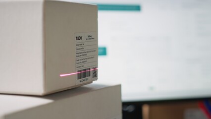 Close up of black employee scanning airway bill tags barcodes, registering the shipping labels numbers in the package tracking software. Using scanner to help with inventory in depot. Camera B.