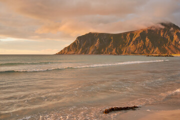 Waves washing the beach at sunset