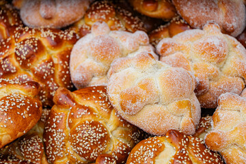 Close-up of sugared and sesame Pan de Muerto, an essential traditional Mexican dessert for the Day of the Dead offering.
