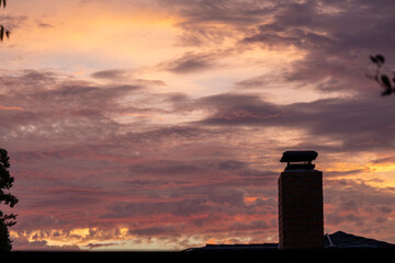 Chimney silhouette against a pastel sunset sky