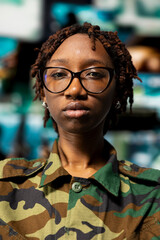 Closeup portrait of soldier in front of command center screens used for surveillance and threat...