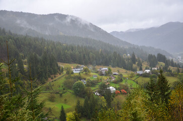 Charming rural mountain Verkhovyna village nestled in picturesque valley, surrounded by verdant...