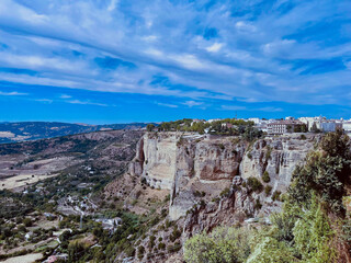 Spektakul&auml;re Felslandschaft von Ronda in Andalusien, Spanien. Historische Altstadt auf steilen Klippen mit weitem Blick &uuml;ber die T&auml;ler und Berge unter blauem Himmel.