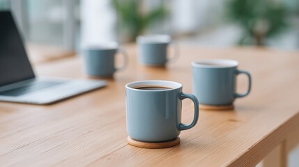 Fototapeta premium foodtech startup strategy A cozy workspace featuring blue coffee mugs on a wooden table with a laptop in the background.