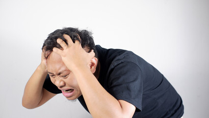 Headache, man and massage temple with pain for dizziness, tired or stress, fatigue and male person with migraine. clutching his head and wincing in pain, depicting a severe headache or migraine.
