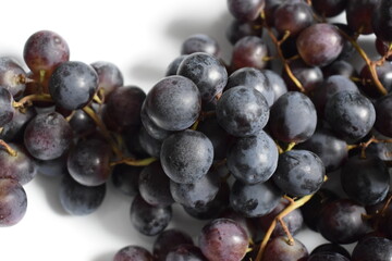 Close up of grape bunch on white plate under natural light