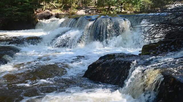 Upper Bond Falls cascading over rock ledges in Michigan&rsquo;s Upper Peninsula, surrounded by forest and sunlight, filmed in 4K 60fps UHD with natural waterfall sound