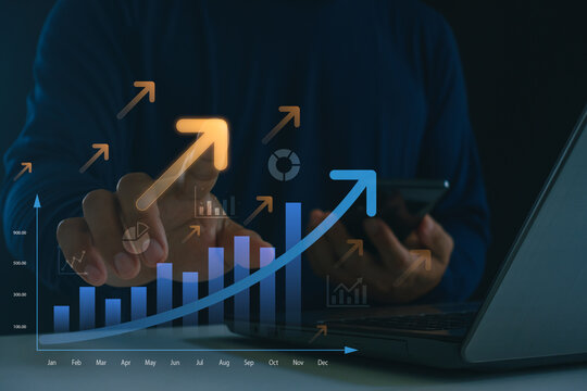 Businessman analyzing financial growth data on laptop and smartphone with digital chart showing rising success, profit increase and business analytics concept in modern technology.