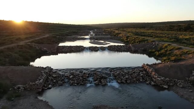 Drone Sweep Over Check Dams Along a Seasonal Stream with Glowing Reflections