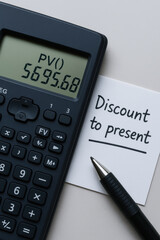 Present value calculation note with calculator pen and paper conveying time value money concept and financial planning motivation