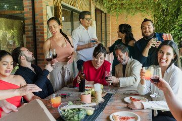 large group of friends or multi generation family eating and having a dinner in a terrace party in Mexico Latin America, hispanic diverse and multicultural people in a restaurant