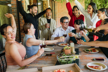 adult latin couple celebrating and toasting with multi generation family and having a dinner in a terrace party in Mexico Latin America, hispanic diverse and multicultural people or friends eating 
