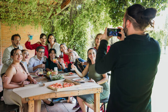 photo selfie with mobile phone of large group of friends or multi generation family eating and having a dinner in a terrace party in Mexico Latin America, portrait of hispanic people