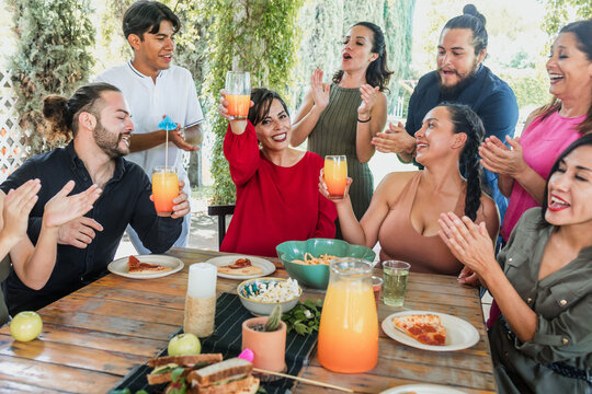 large group of friends or multi generation family eating and having a dinner in a terrace party in Mexico Latin America, hispanic diverse and multicultural people in a restaurant - Powered by Adobe