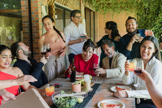 large group of friends or multi generation family eating and having a dinner in a terrace party in Mexico Latin America, hispanic diverse and multicultural people in a restaurant