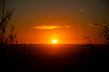 Hermoso paisaje de un atardecer en el horizonte del desierto de Sonora con nubes de color rojo y luz solar anaranjada sobre las olas de la costa en verano