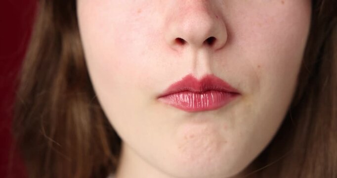 Woman with beautiful lips eating cherry on red background, closeup