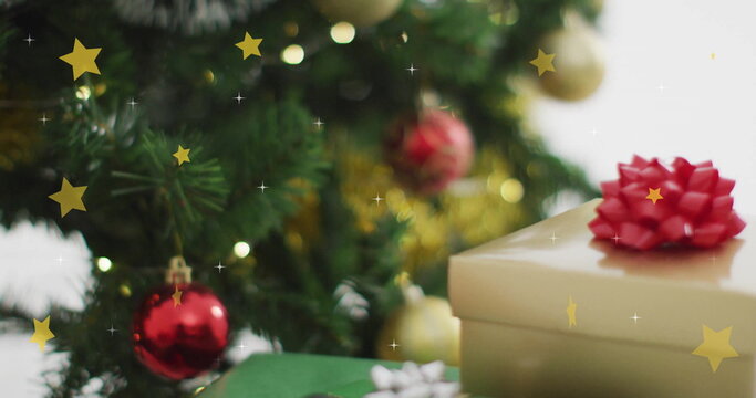 Naklejki Christmas tree with ornaments and gift boxes over falling stars image