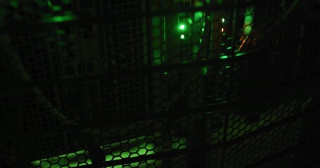 Lighting hexagonal metal mesh grille in rack, showing board edges, green LEDs and power or data cabl