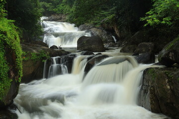 Fototapeta premium Nang Rong waterfall is a multi-tiered waterfall plunges down to several rock formations below, and then flows into the lush surrounding forests ,Nakhon Nayok province ,Thailand 