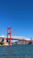 Iconic suspension bridge spanning a bay with red towers against a blue sky, iconic structure, travel destination