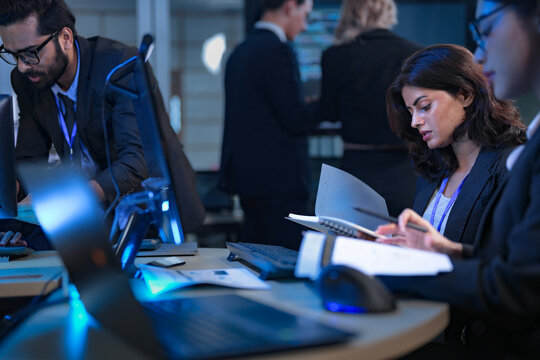 In a 24 7 Security Operations Center, a diverse incident response team works together under pressure, analyzing real-time threat intelligence data to defend against a live cyberattack. - Powered by Adobe