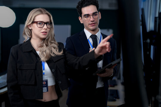 A quantum computing scientist explains a complex algorithm to a colleague, pointing to the code that will run on a quantum processor to solve a problem previously thought impossible.