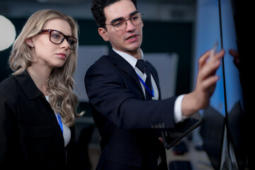 A quantum computing scientist explains a complex algorithm to a colleague, pointing to the code...