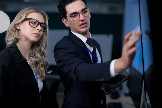 A quantum computing scientist explains a complex algorithm to a colleague, pointing to the code that will run on a quantum processor to solve a problem previously thought impossible.