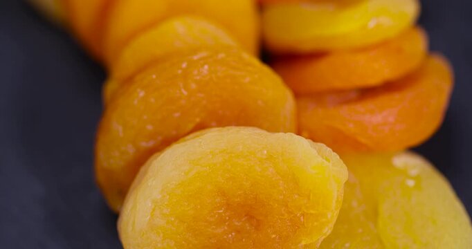 dried ripe orange apricot fruits on a black slate , dried seedless pure dried apricots for long-term storage and used as a sweet or for making compotes