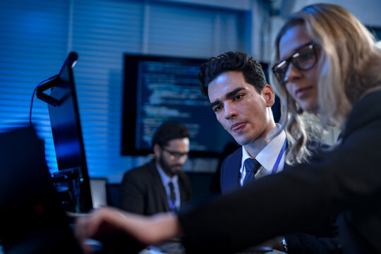 A diverse team of young professionals engages in intensive training, diligently taking notes from a presentation in a modern classroom, focused on their career growth and development. - Powered by Adobe