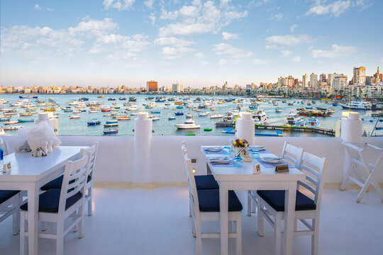 View of the marina, skyline and waterfront corniche road from a terrace at Alexandria Bay, at the port of Alexandria, Egypt. - Powered by Adobe