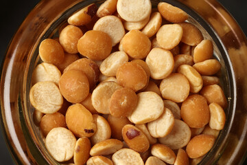 Top down flat lay view of split peas chana buter dal in mini glass jar on dark black slate background