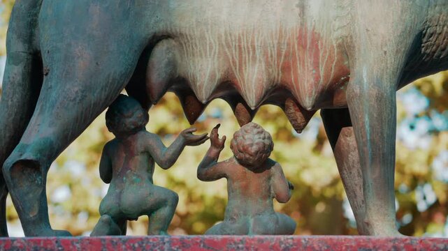 Historic bronze statue of the Capitoline Wolf with Romulus and Remus on a red marble pedestal in front of the National History Museum of Moldova, Chisinau
