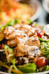 Grilled chicken breast salad in a bright restaurant environment