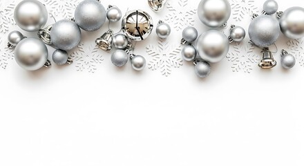 A collection of silver Christmas ornaments and bells scattered on a white snowflake background.