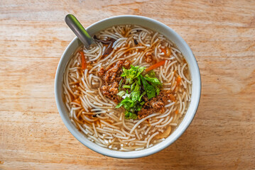 Rice noodle thick soup on wooden table 
