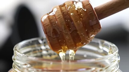 Honey dripping from wooden dipper.