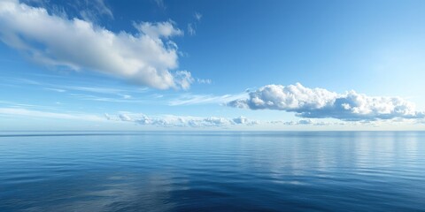 Fototapeta premium A vast, calm ocean with a few scattered clouds in a bright blue sky, reflecting on the water's surface.