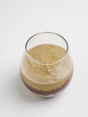 Avocado smoothies in transparent glass on white background