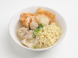 Meatball soup with noodles and fried dumpling in white bowl
