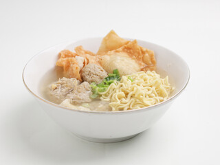 Meatball soup with noodles and fried dumpling in white bowl