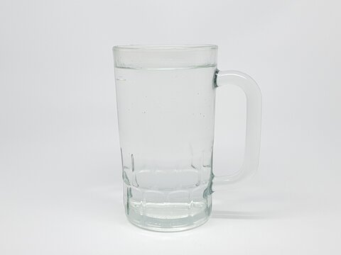 Clear glass mug filled with clean drinking water on a white background, minimal and refreshing look.